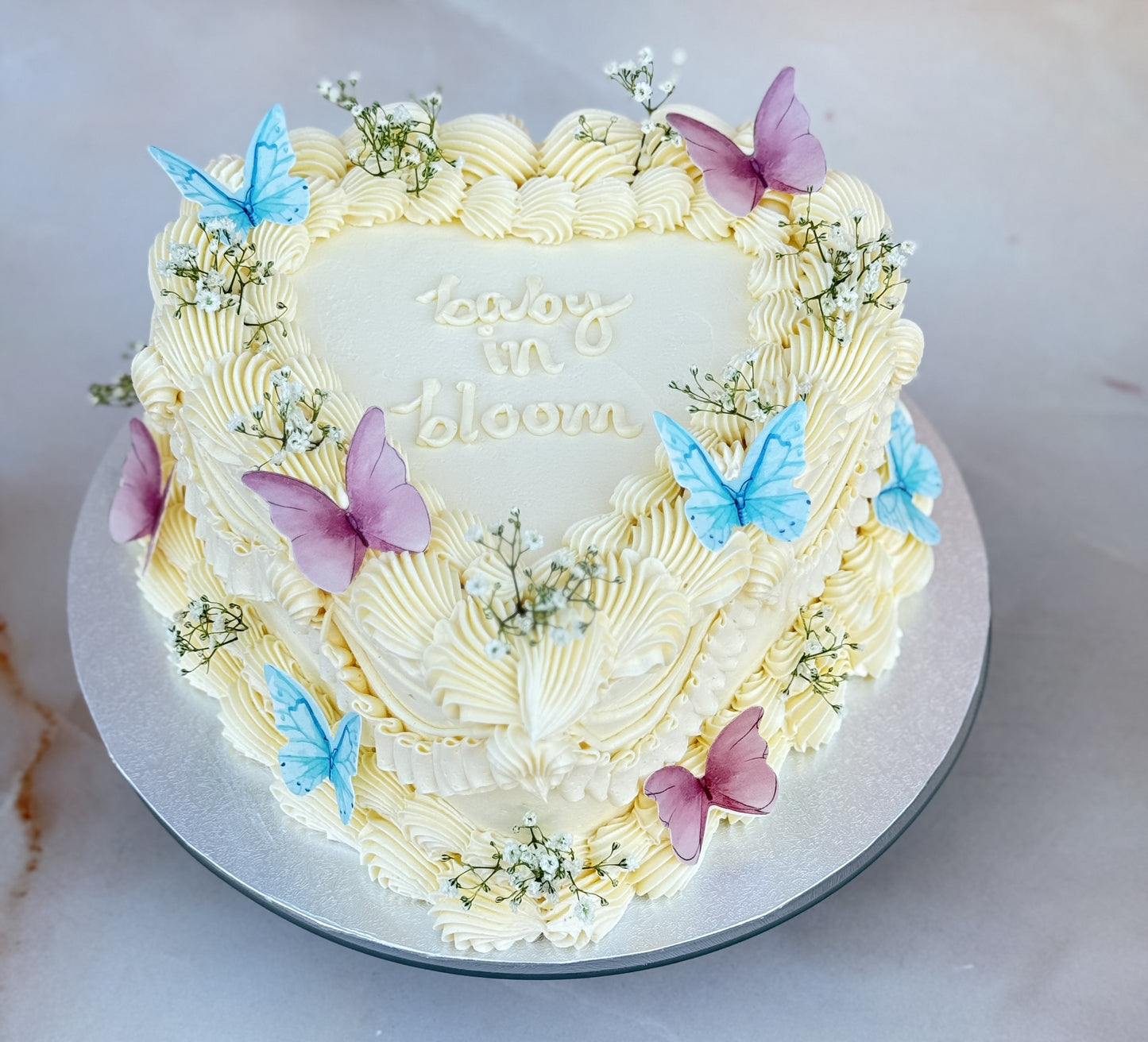 Elegant vintage-style baby shower cake with pink and blue butterfly decor, handcrafted in London and available for same-day cake delivery.