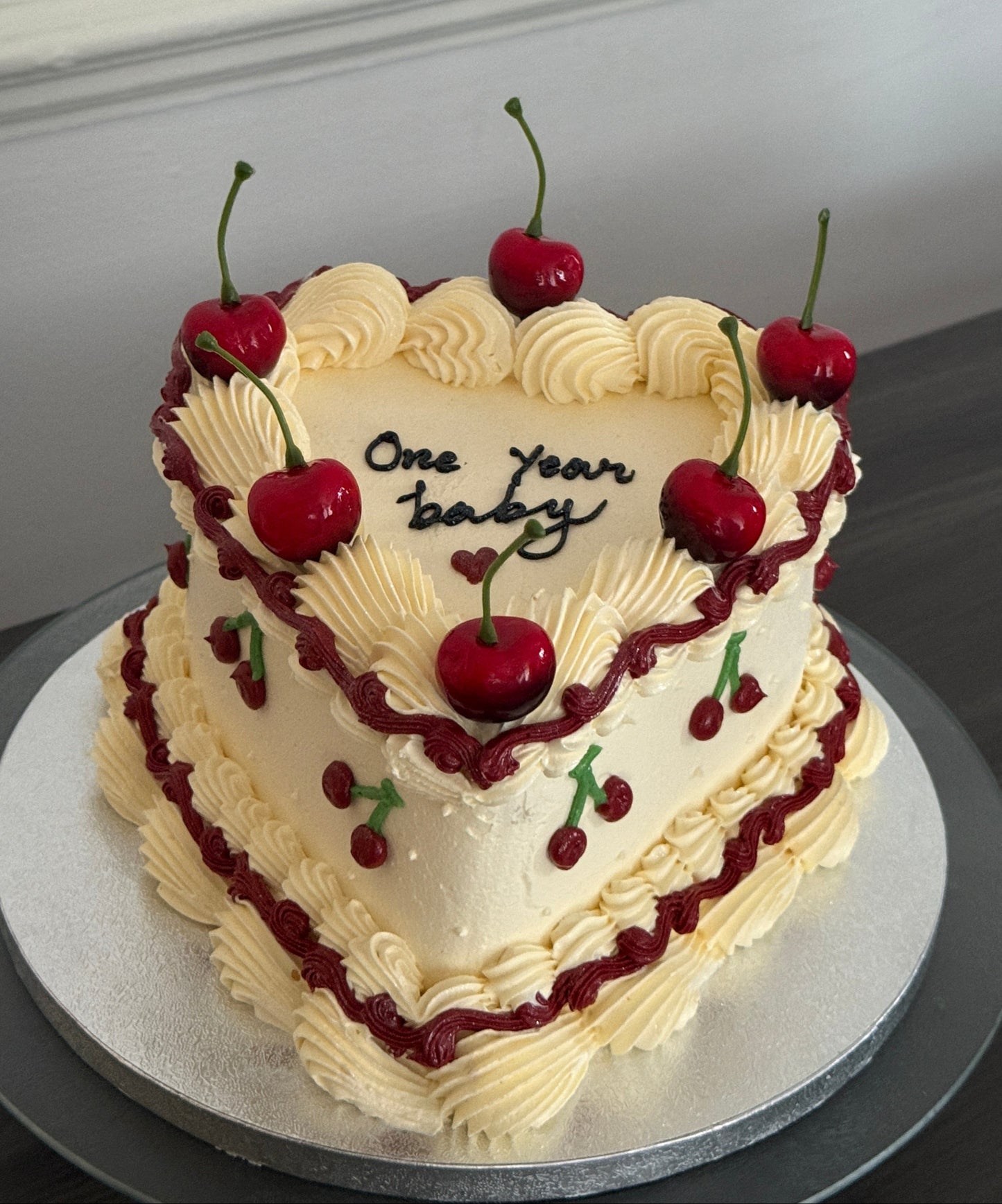 Custom one year celebration heart cake decorated with cherries and vintage buttercream design – available for cake delivery in Barking, Dagenham, and Ilford.