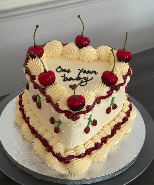 Custom one year celebration heart cake decorated with cherries and vintage buttercream design – available for cake delivery in Barking, Dagenham, and Ilford.