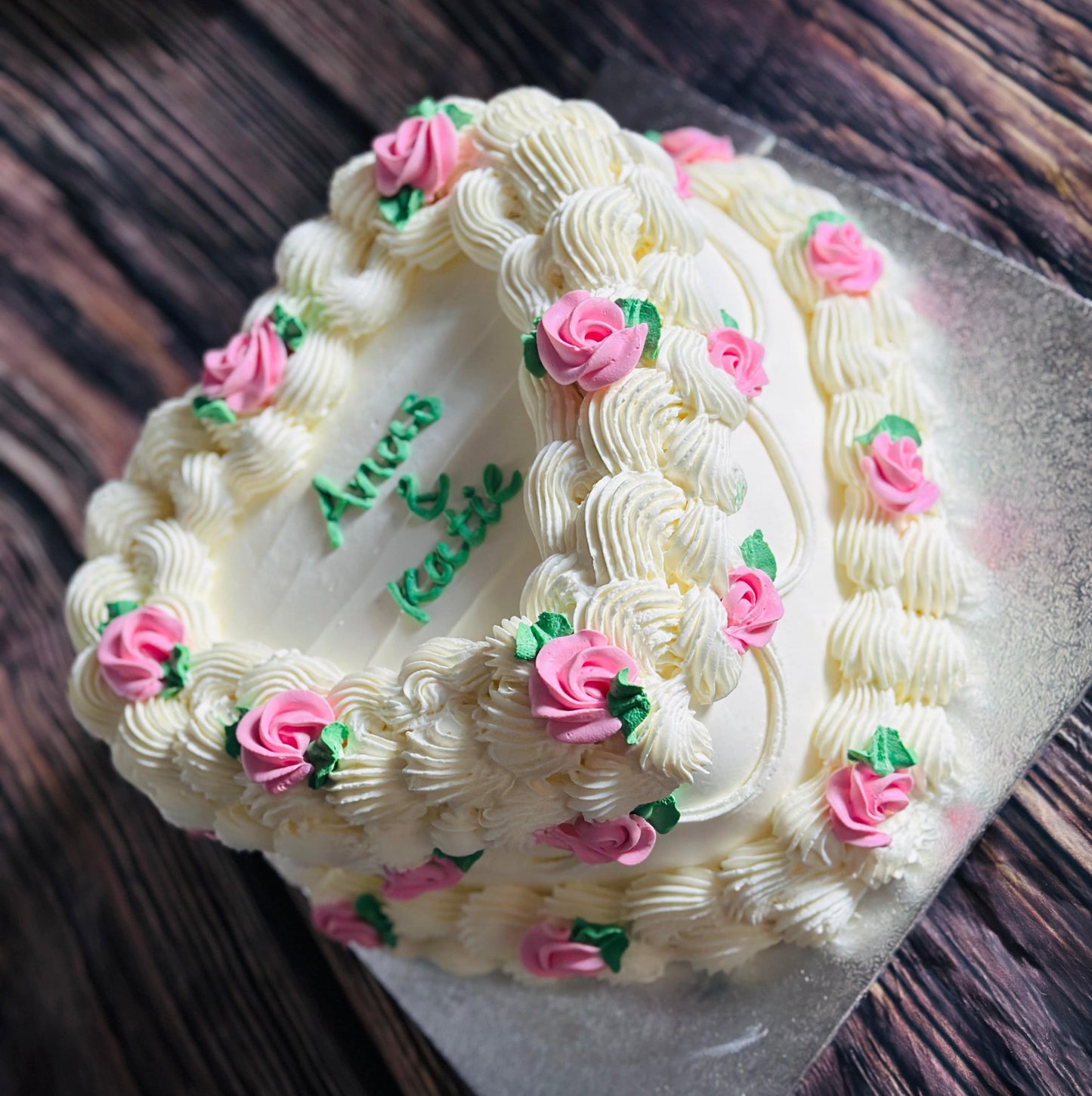 Custom white buttercream heart cake with floral pink decoration, handmade for celebrations in Barking and Walthamstow.