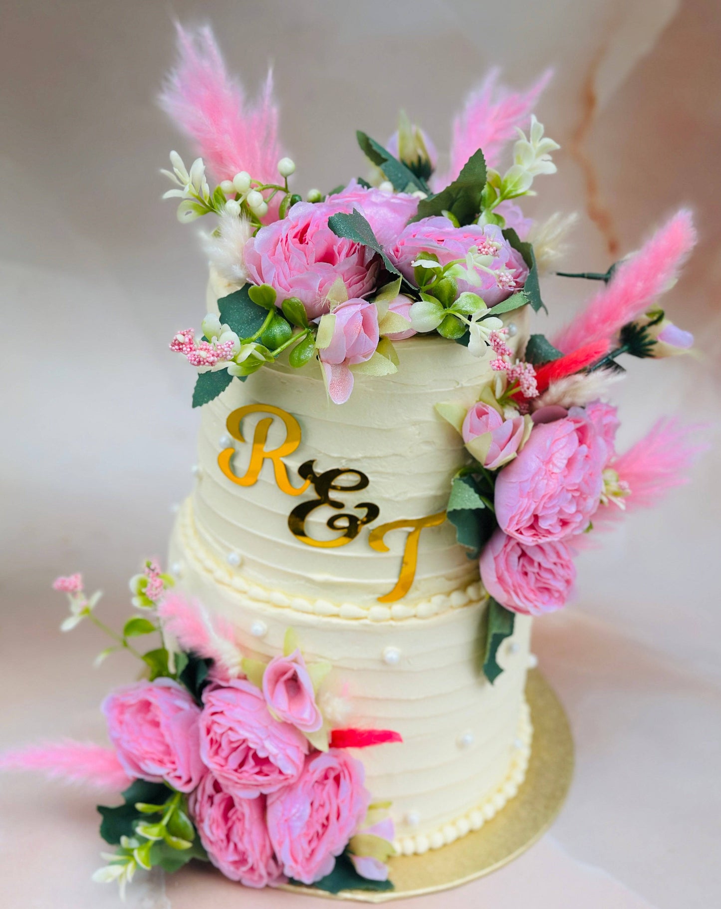 Elegant floral wedding cake with fresh pink flowers, available for wedding delivery in Romford and Ilford.