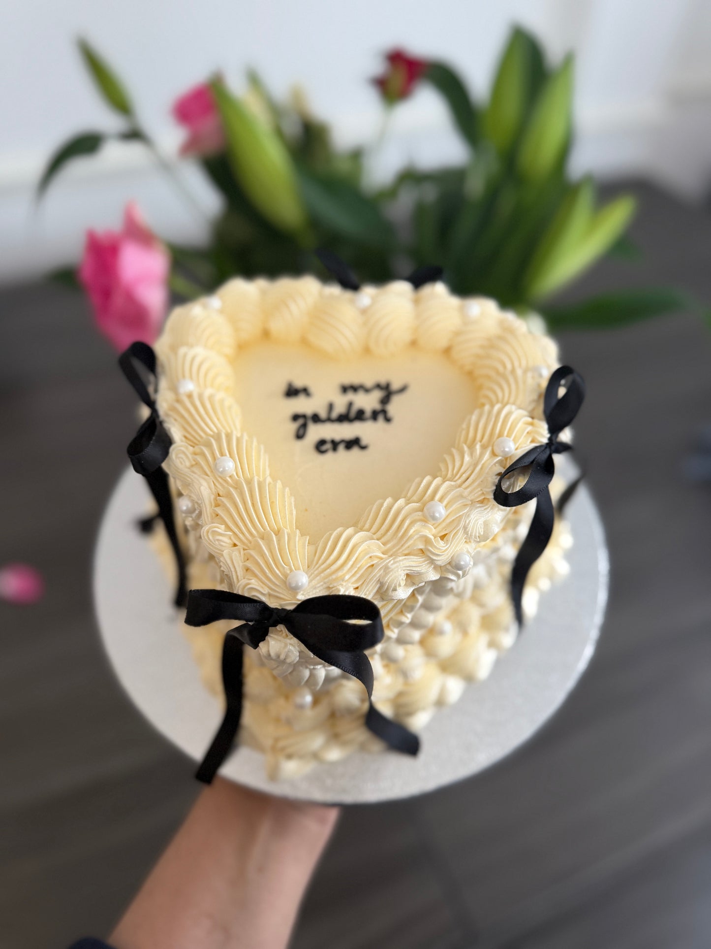 Ivory vintage heart cake with decorative piping, black ribbon bows, and pearl accents – order online from CakeTrays.co.uk for delivery across East Ham, Walthamstow, and Romford.