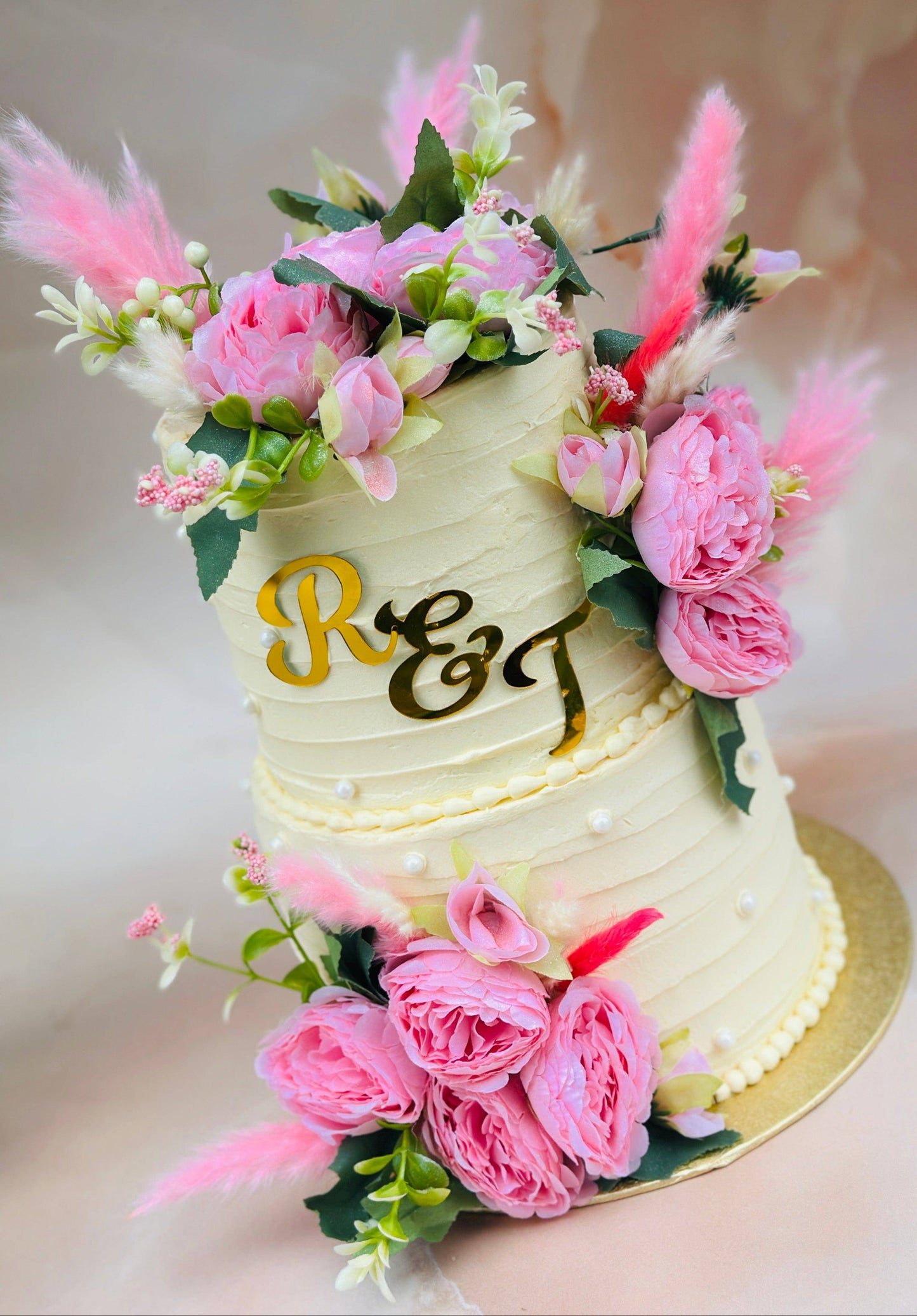 Luxury two-tier wedding cake decorated with pink florals, crafted for couples in Dagenham and East London.