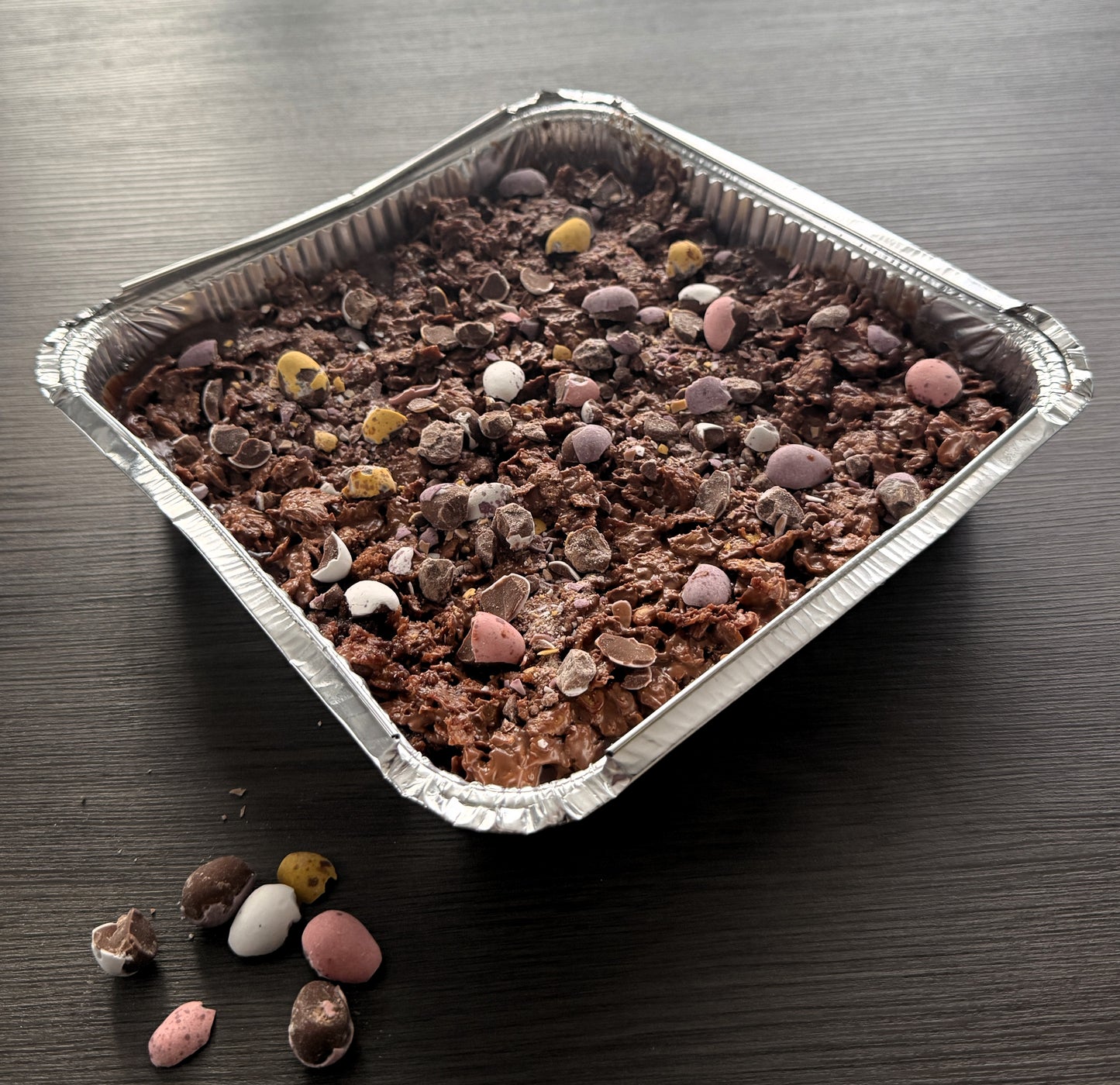 A full Mini Eggs Crunch Cake Tray topped with crushed chocolate candy and a crispy cornflake layer ready for fresh delivery in East London.