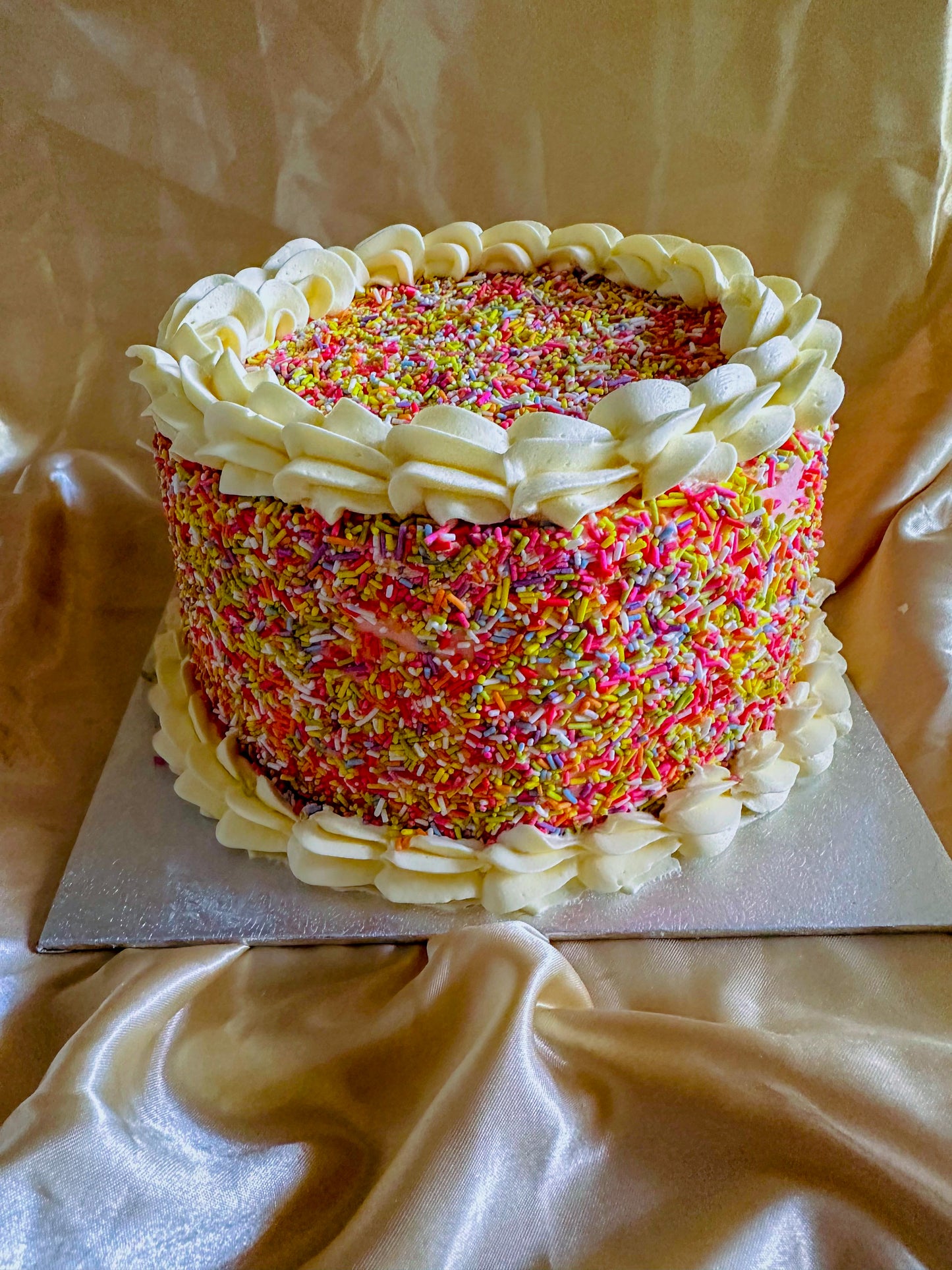 Rainbow sprinkle cake with piped borders, fast delivery to Walthamstow and Leyton.
