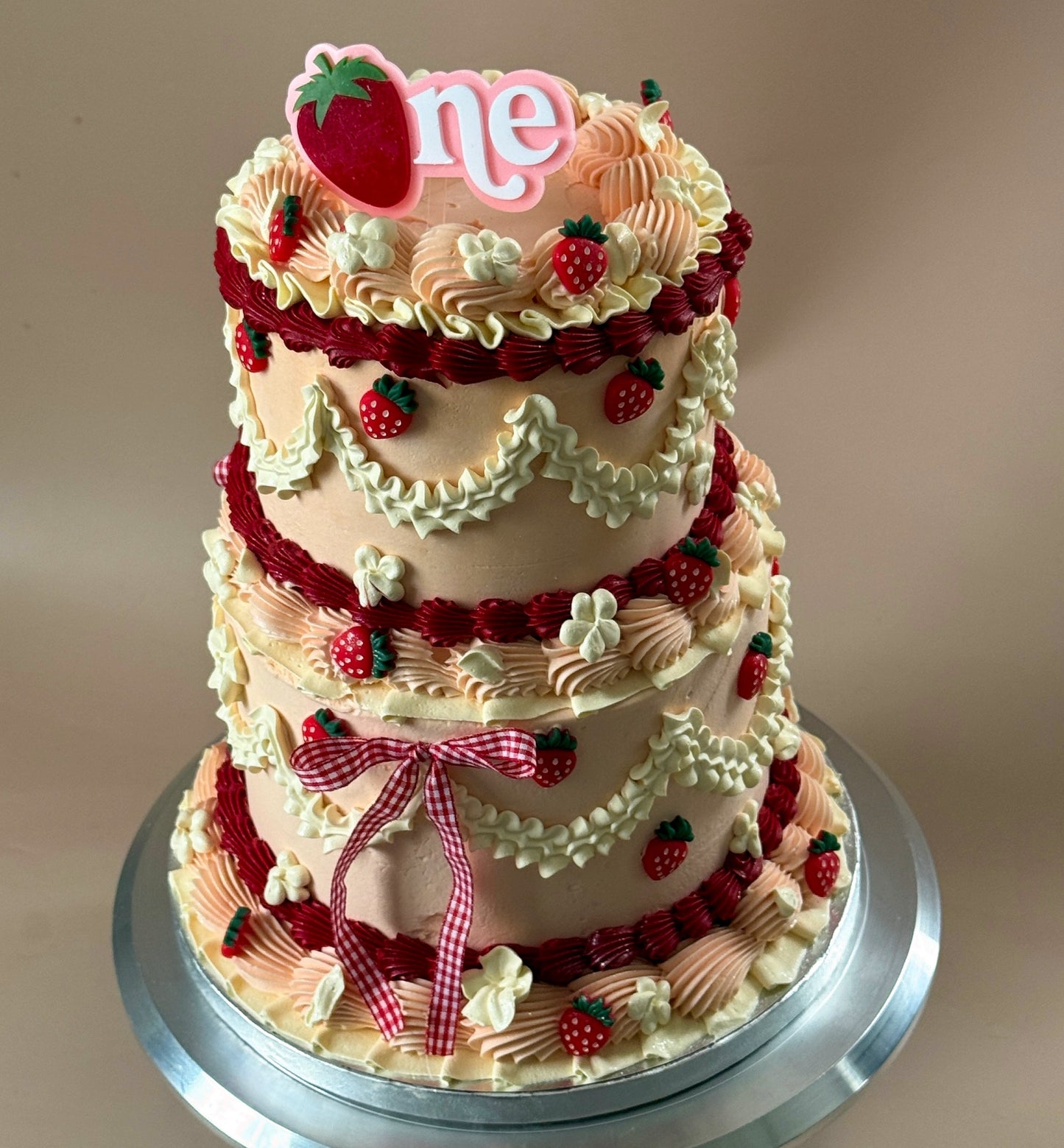 Top angle of the strawberry vintage first birthday cake showing piped swags and sugar strawberries — custom cakes East London, Romford and Ilford.