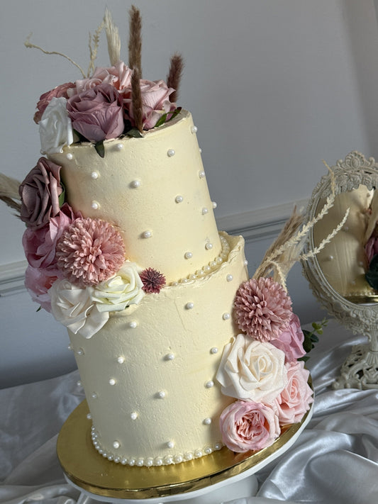 Custom two-tier wedding cake with personalised gold initials topper and ivory buttercream, designed and baked by Cake Trays for East London delivery