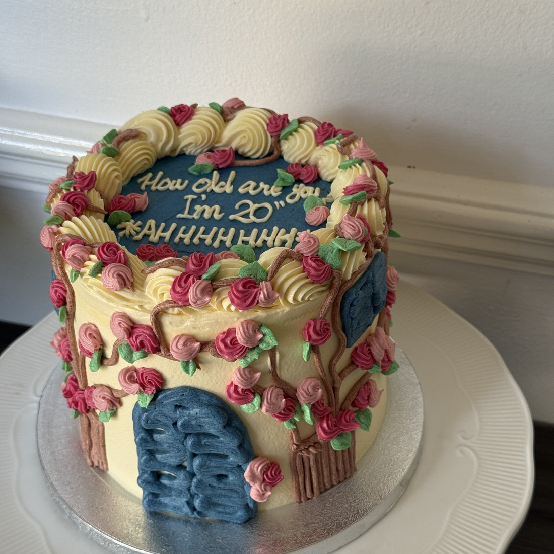 Vintage style birthday cake with piped buttercream roses, trailing vines and a personalised 20th birthday message, baked by Cake Trays for a customer in East London