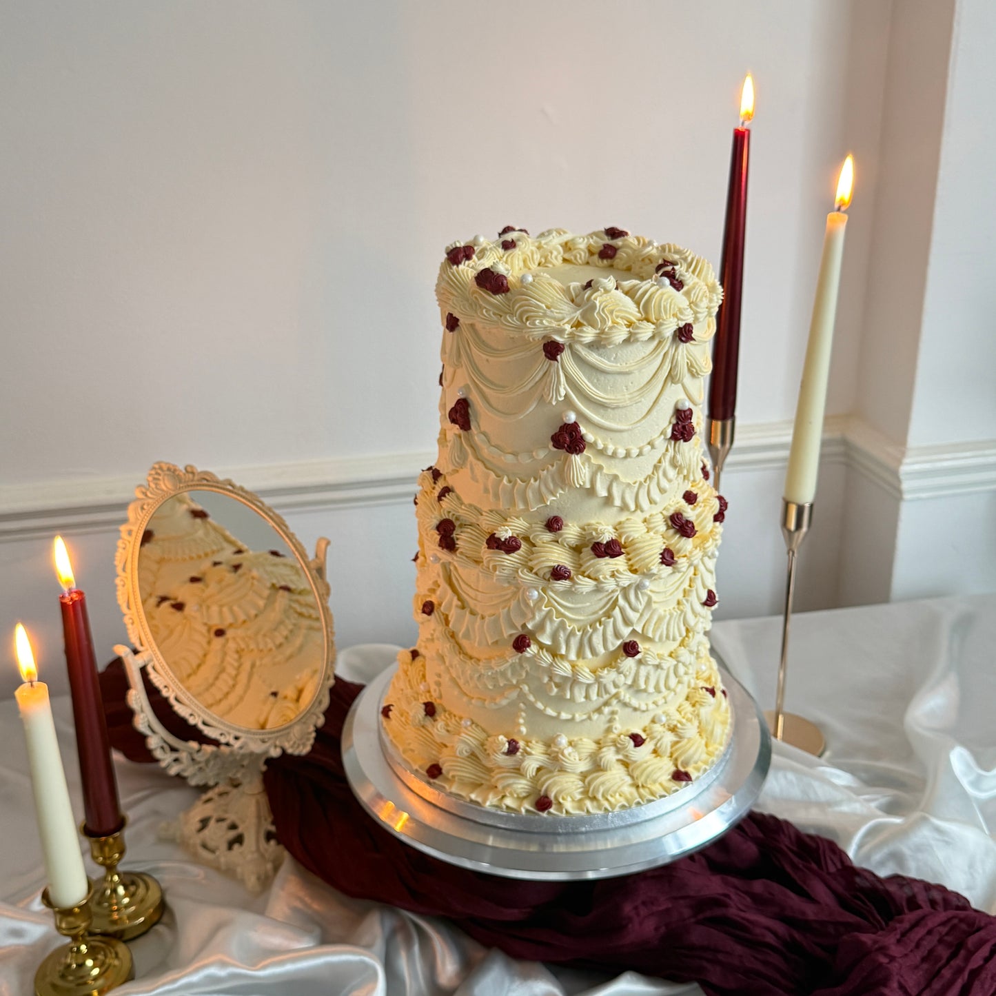 Vintage Burgundy Pearl Lambeth Two-Tier Wedding Cake with ivory buttercream swags, burgundy mini roses and pearl accents, available for delivery in Romford RM1 and Ilford IG1.