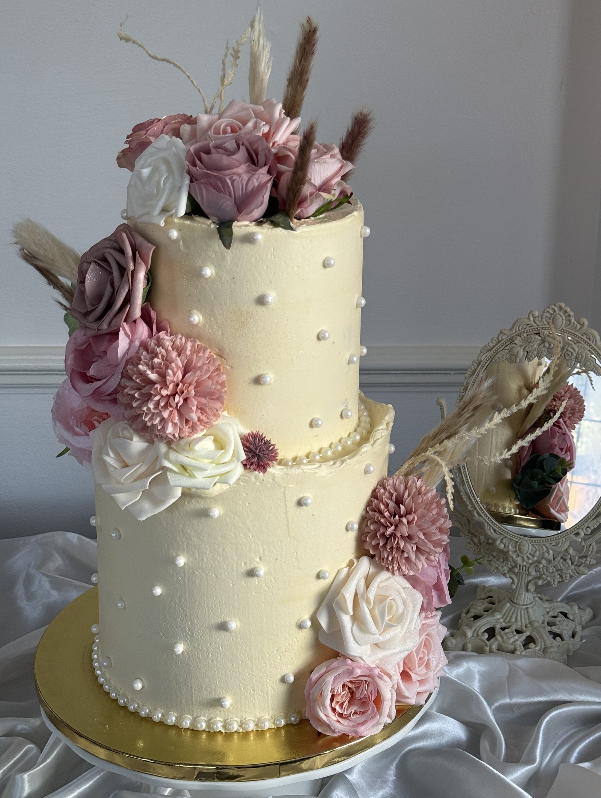Front view of a pearl-dotted offset two tier buttercream cake with blush florals, delivered by Cake Trays in Barking and Dagenham.