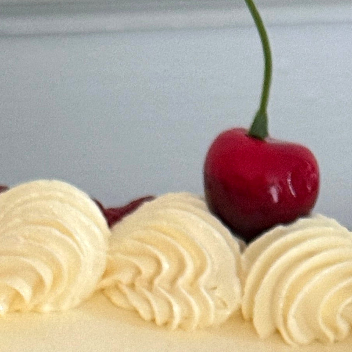 Fresh cherry on cream shell piping along the rim of a vintage heart anniversary cake, delivered to Chigwell