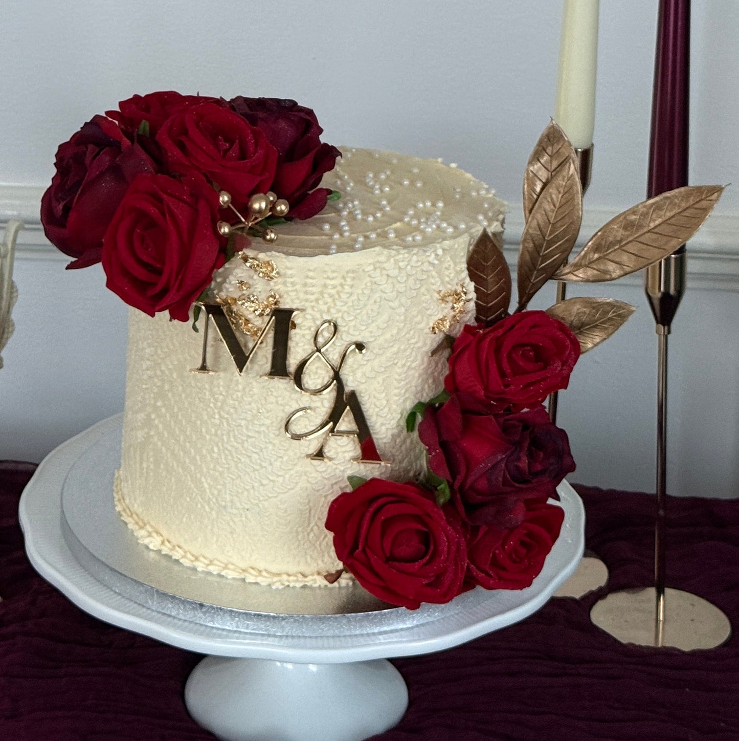 Romantic wedding cake with deep crimson silk roses, gold leaf accents and edible pearls handmade for Nikkahs and engagements in East London