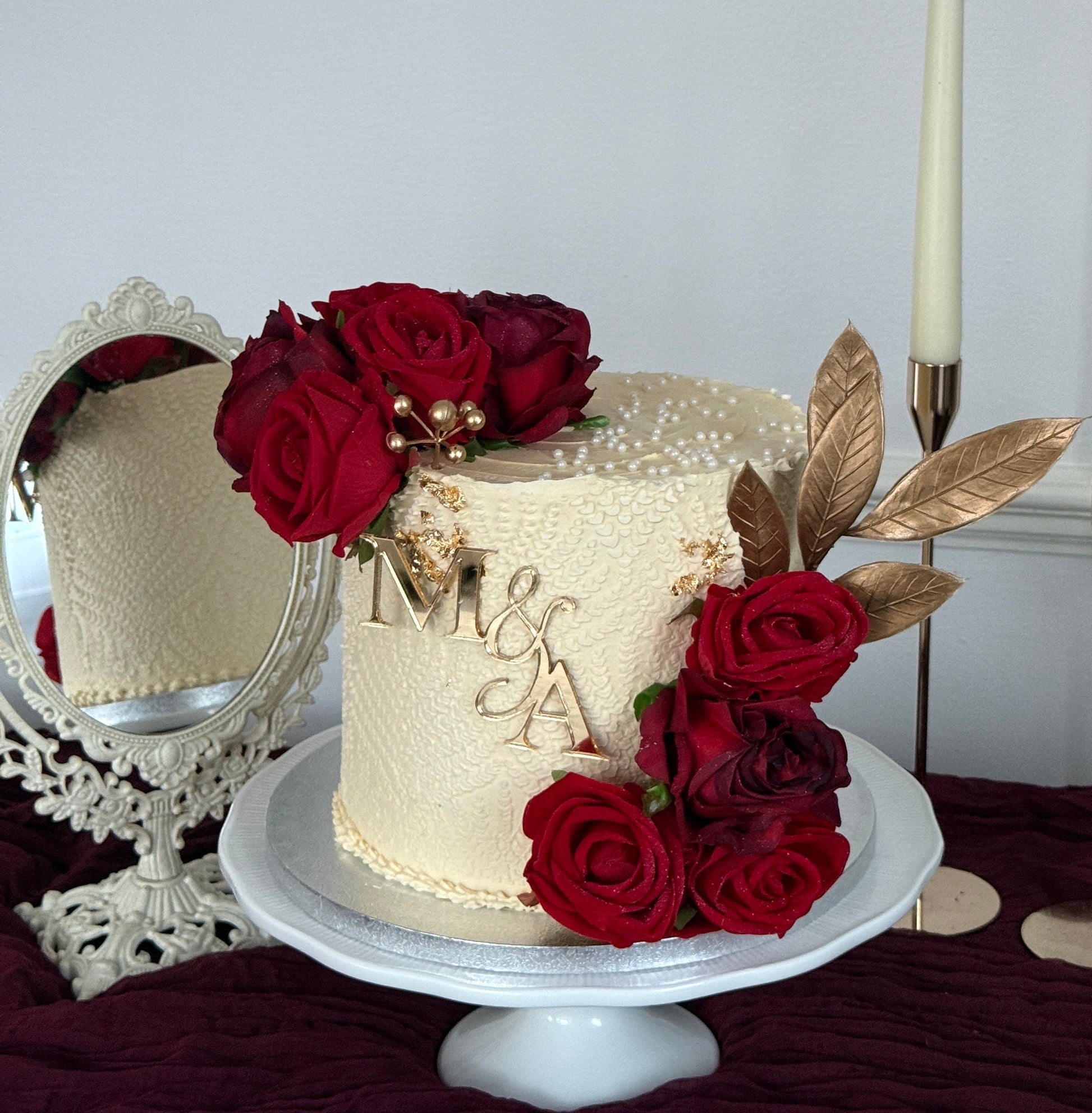 Crimson Rose and Gold single tier ivory buttercream wedding cake with red roses and personalised M and A gold monogram topper from Cake Trays East London