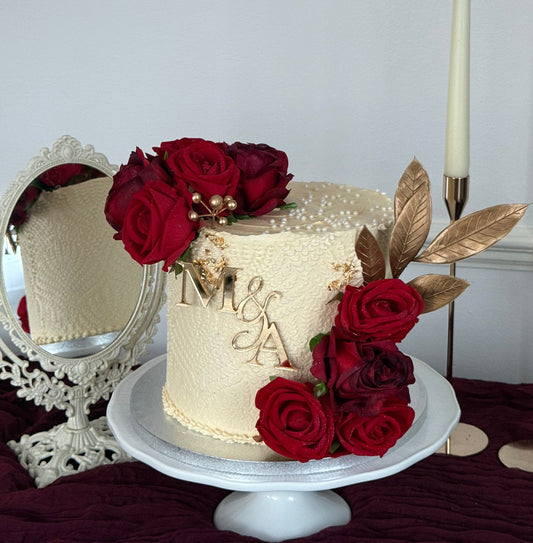 Crimson Rose and Gold single tier ivory buttercream wedding cake with red roses and personalised M and A gold monogram topper from Cake Trays East London