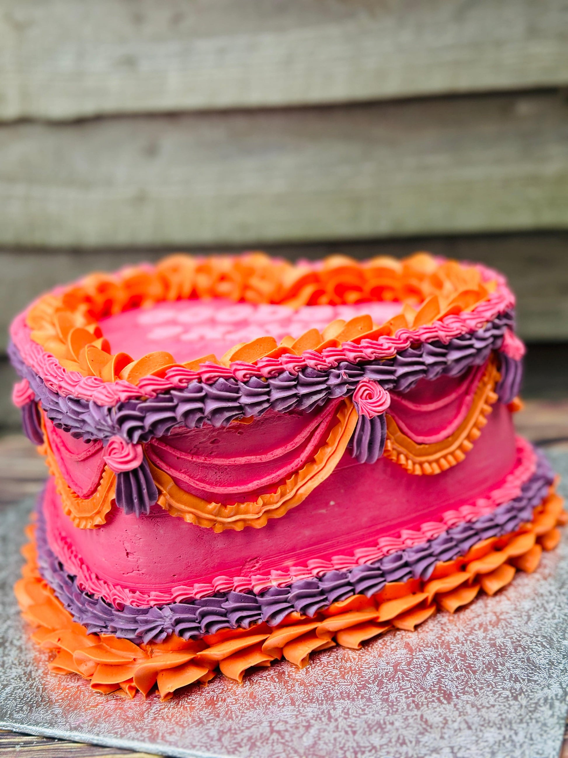 Custom heart-shaped cake with vibrant piping and farewell message, delivered in East Ham.