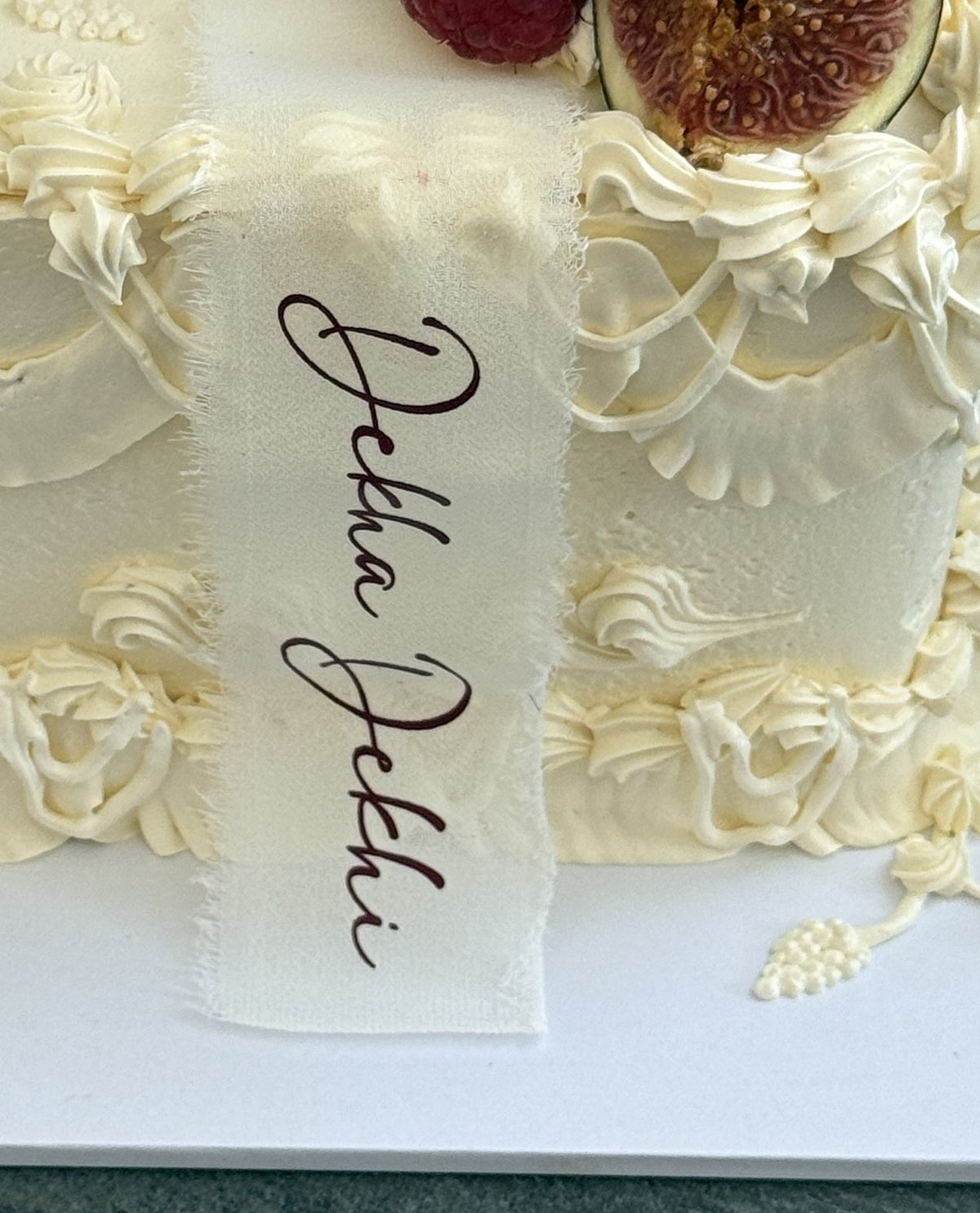 Close up of the Dekha Dekhi calligraphy ribbon and Lambeth piping, custom cakes East London, Romford and Ilford.