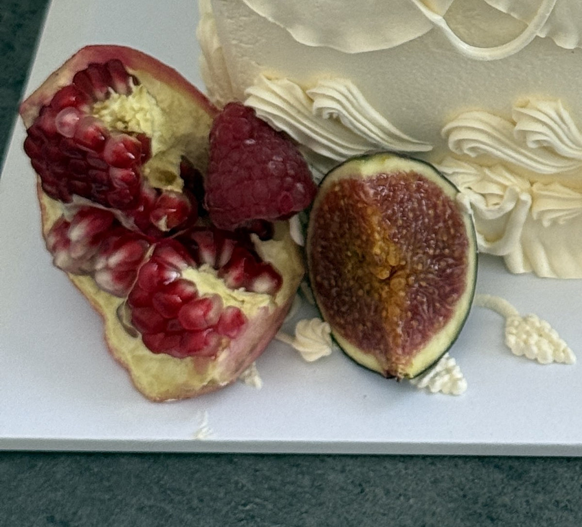 Close up of pomegranate and fig styled beside the cake, custom cakes East London, Romford and Ilford.