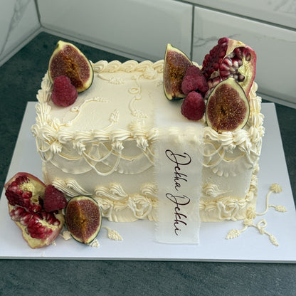 Ivory vintage sheet cake with figs, raspberries, pomegranate and a Dekha Dekhi calligraphy ribbon, custom cakes East London, Romford and Ilford.