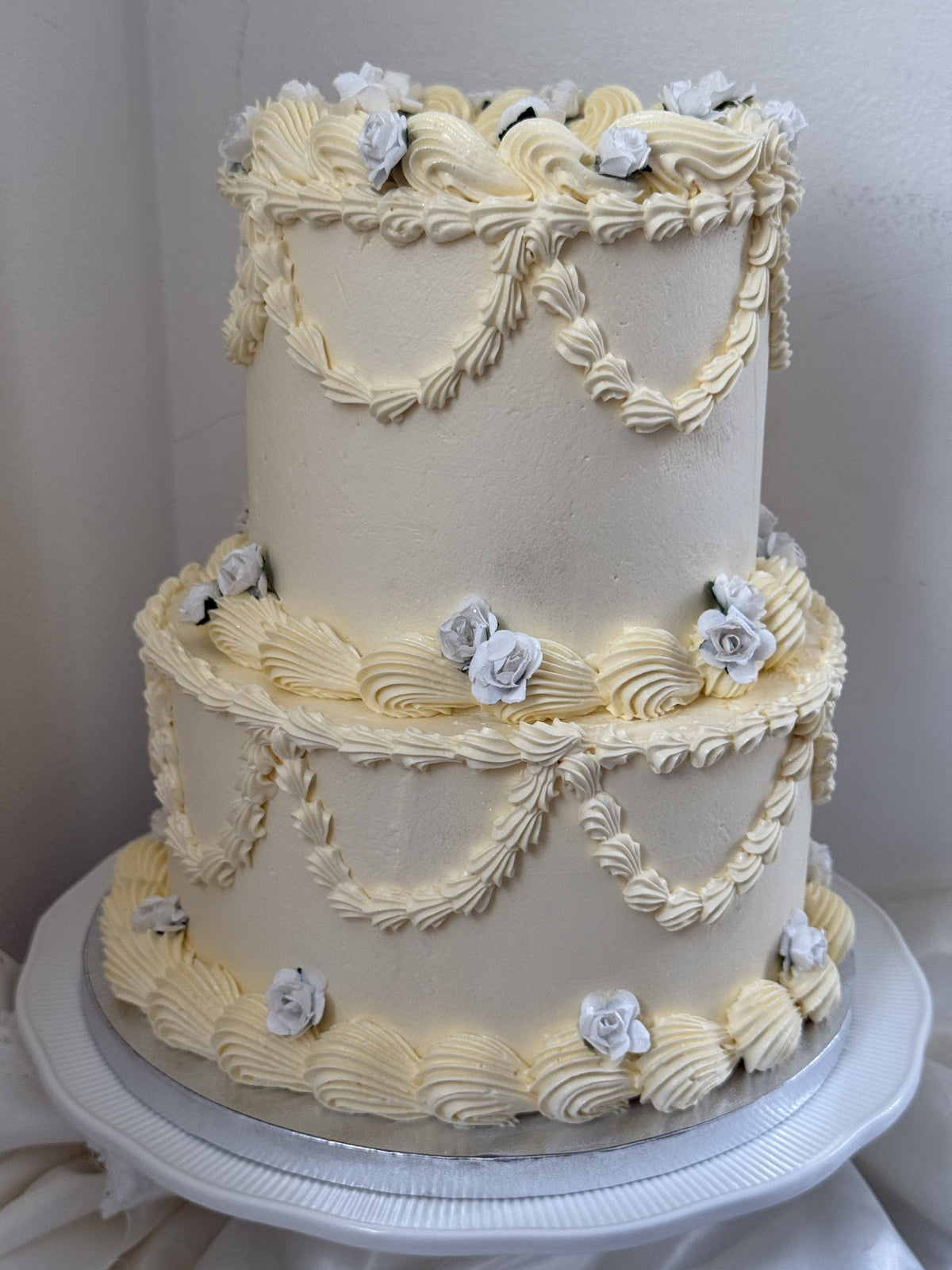 Side view of the ivory and dusty blue vintage two-tier cake, custom cakes East London, Romford and Ilford.