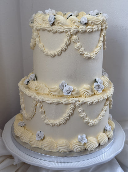 Side view of the ivory and dusty blue vintage two-tier cake, custom cakes East London, Romford and Ilford.