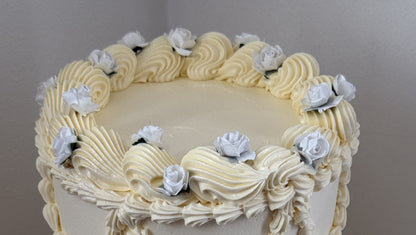Close up of the top tier shell border and dusty blue roses, custom cakes East London, Romford and Ilford.