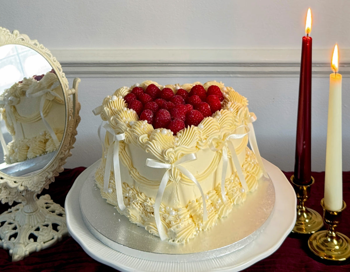 Close up of raspberries and pearls on ivory heart cake, custom cakes East London, Romford and Ilford.