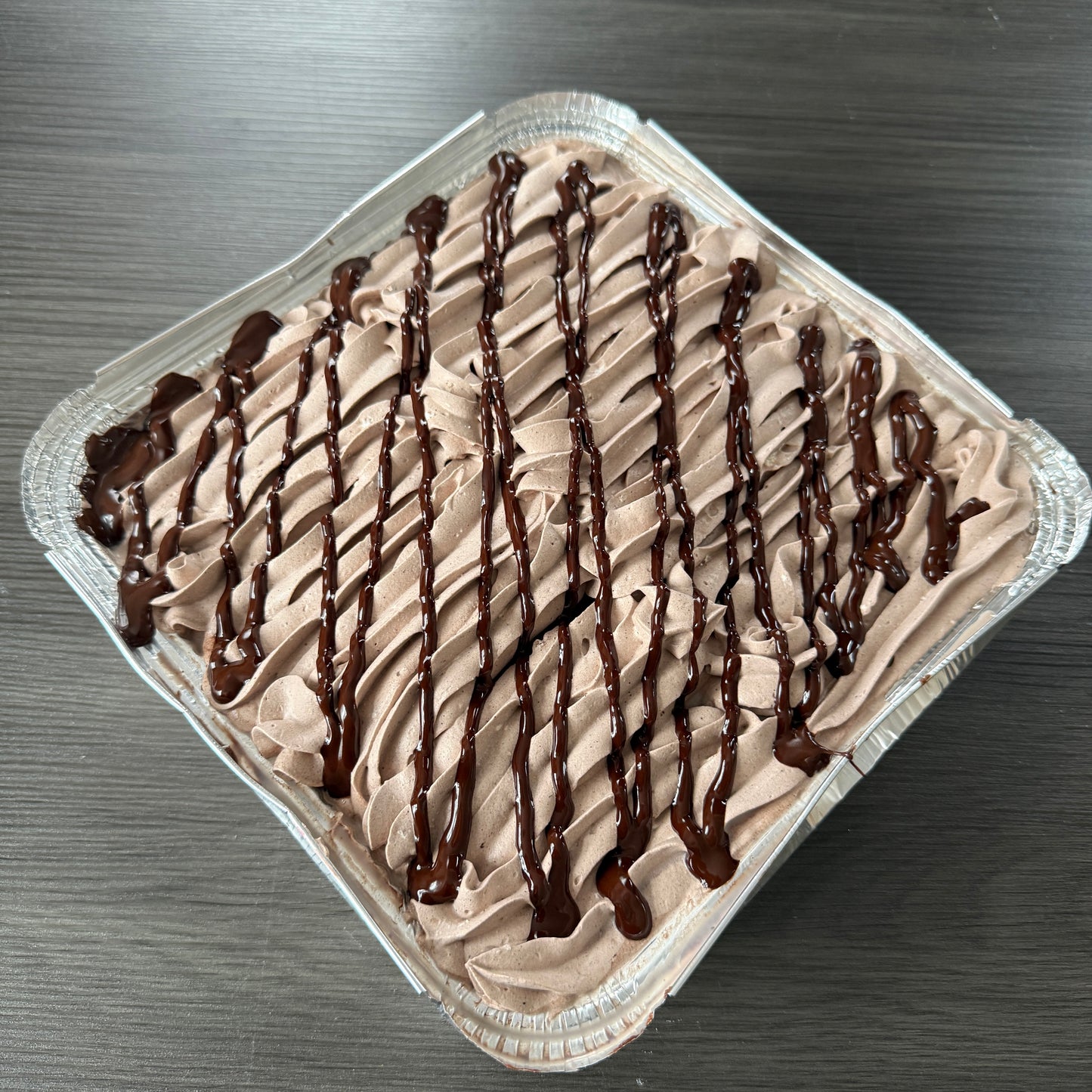 Side view of a moist chocolate sponge milk cake tray, freshly prepared for local customers in Stratford and East London.