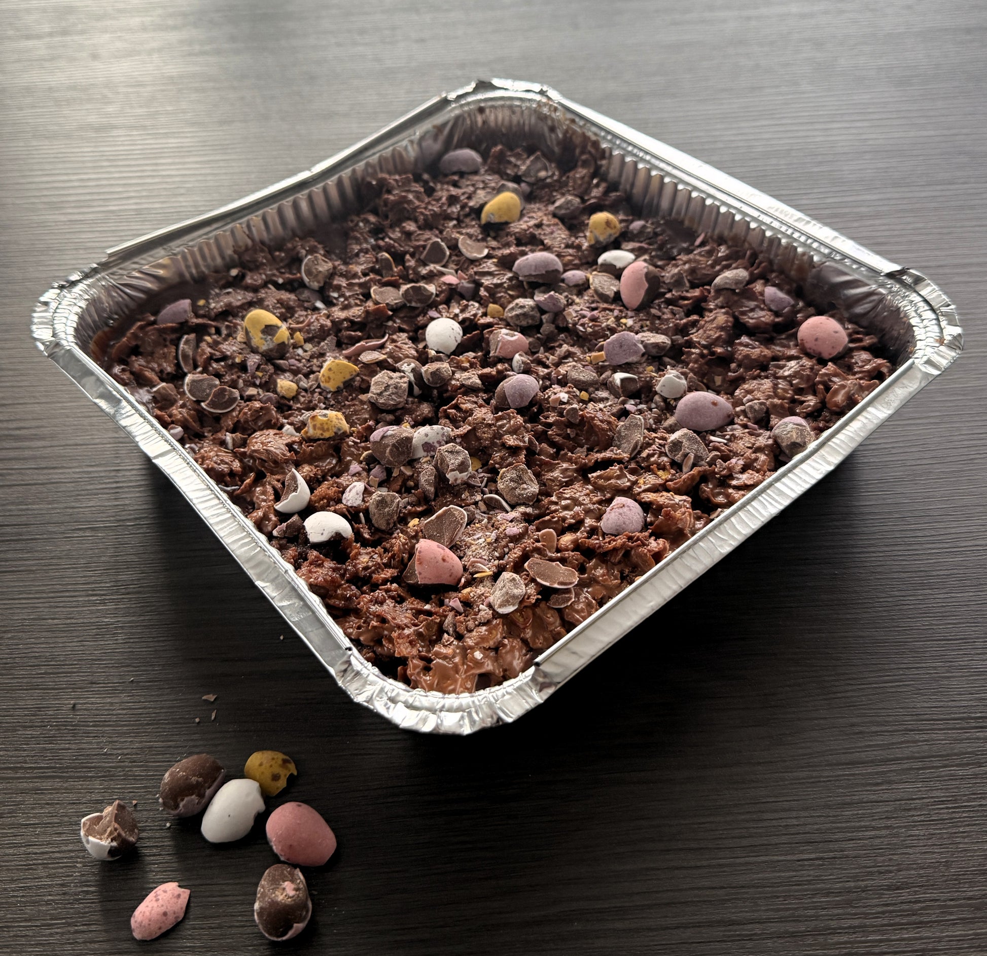 A full Mini Eggs Crunch Cake Tray topped with crushed chocolate candy and a crispy cornflake layer ready for fresh delivery in East London.