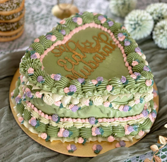 Pastel green floral heart cake with pink and purple buttercream roses, available for delivery in Romford and Forest Gate.