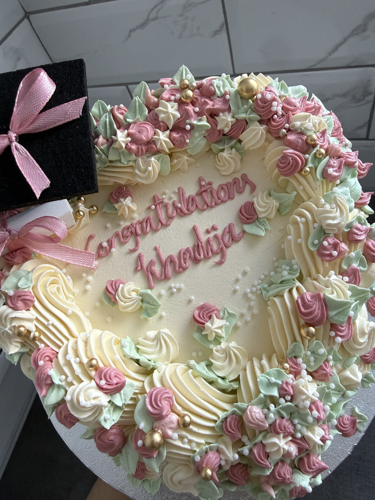 Close up of the piped congratulations message and rosettes on the heart cake, custom cakes East London, Romford and Ilford.