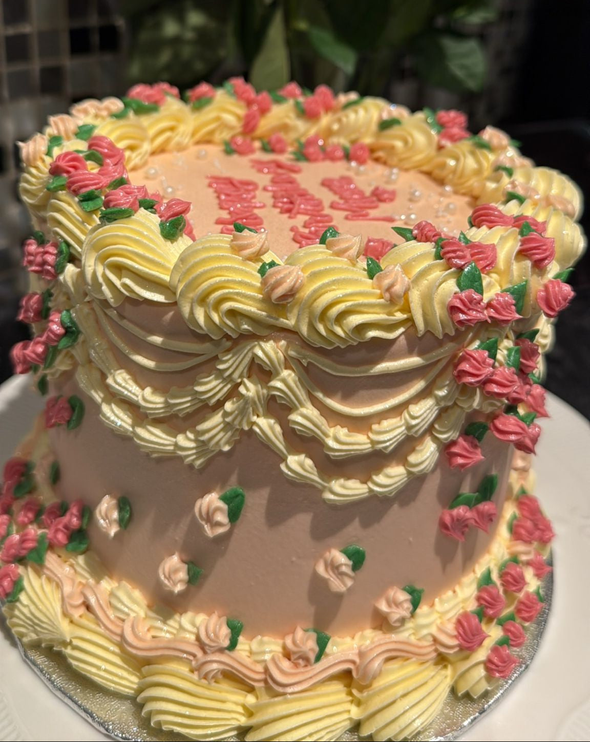 Blush peach vintage Lambeth cake with pale-lemon swags and pink rosebuds — custom cakes East London, Romford.