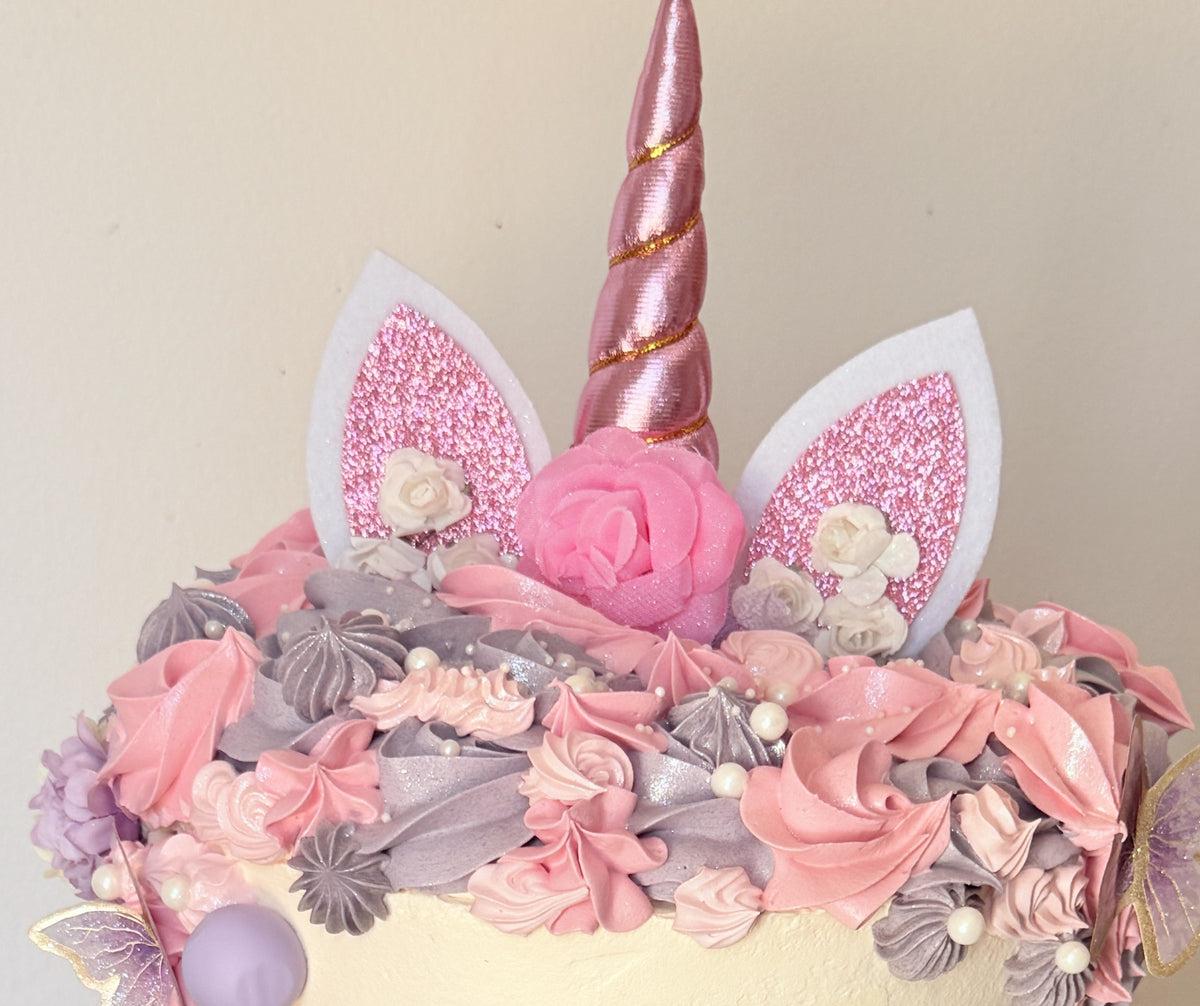 Close up of the rose gold unicorn horn, glitter ears and buttercream rosettes, custom cakes East London, Romford and Ilford.