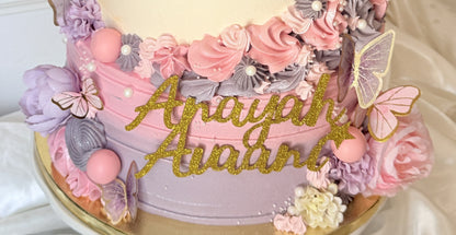 Close up of the lilac base with gold glitter names and butterflies, custom cakes East London, Romford and Ilford.