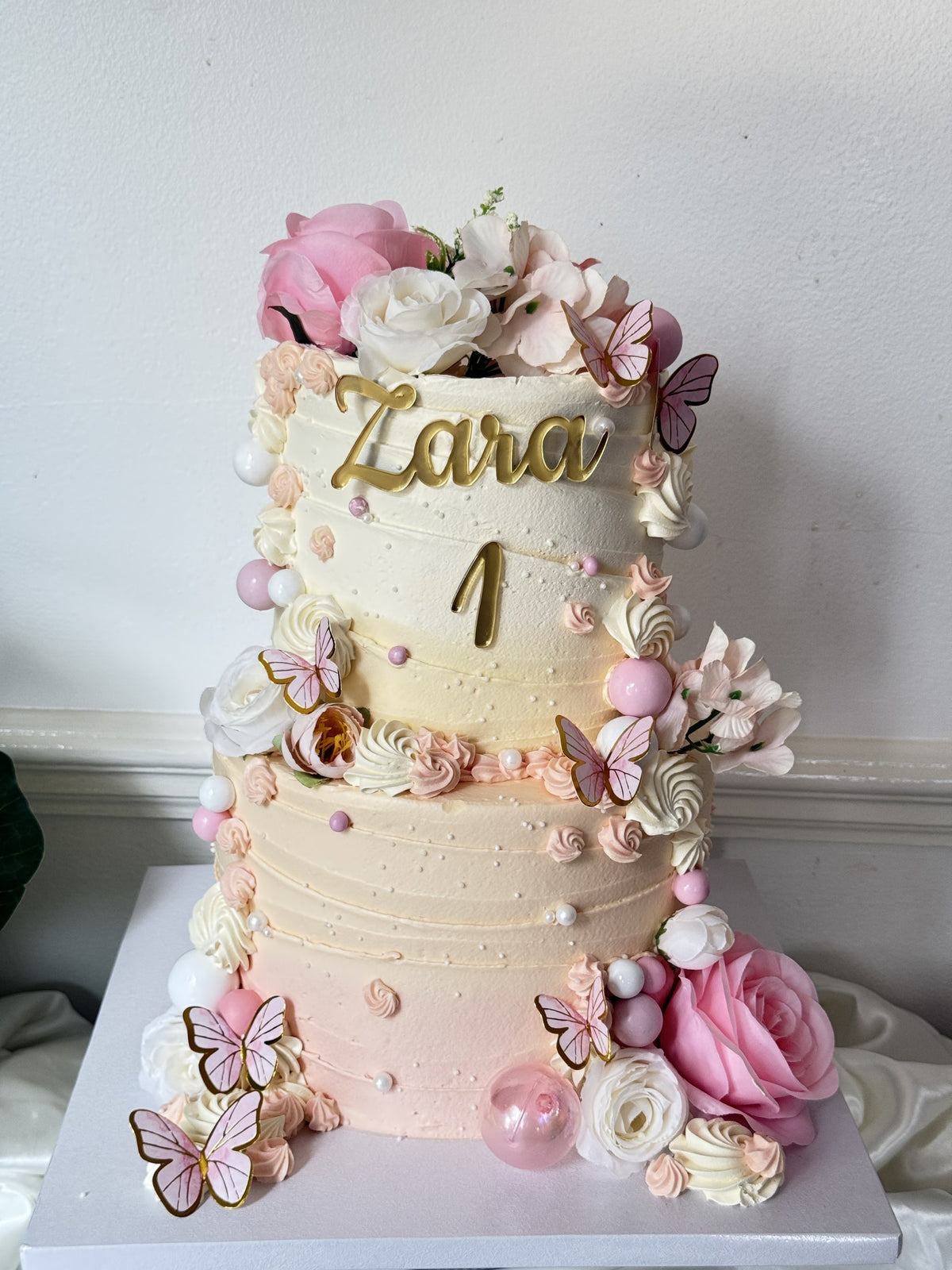 Full view of the pink rose and butterfly first birthday cake on its board, custom cakes East London, Romford and Ilford.