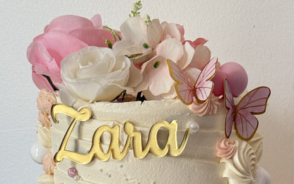 Close up of the rose crown, butterflies and gold name plaque on the top tier, custom cakes East London, Romford and Ilford.