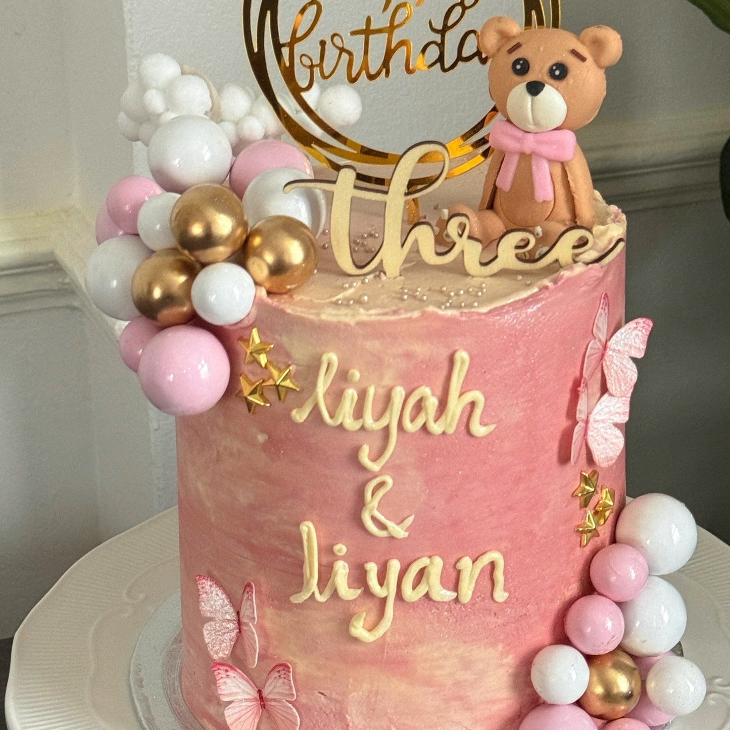 Close up of teddy bear and butterflies on pink birthday cake, custom cakes East London, Romford and Ilford.