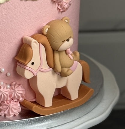 Close up of the teddy bear on a rocking horse at the base, custom cakes East London, Romford and Ilford.