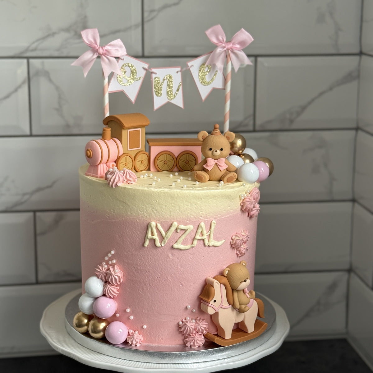 Pink ombre first birthday cake with toy train, teddy bear and One bunting, custom cakes East London, Romford and Ilford.