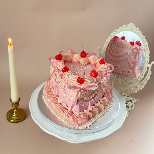 Pink heart-shaped vintage Lambeth piped cake with cherries and pink ribbon bows — custom cakes East London, Romford and Ilford