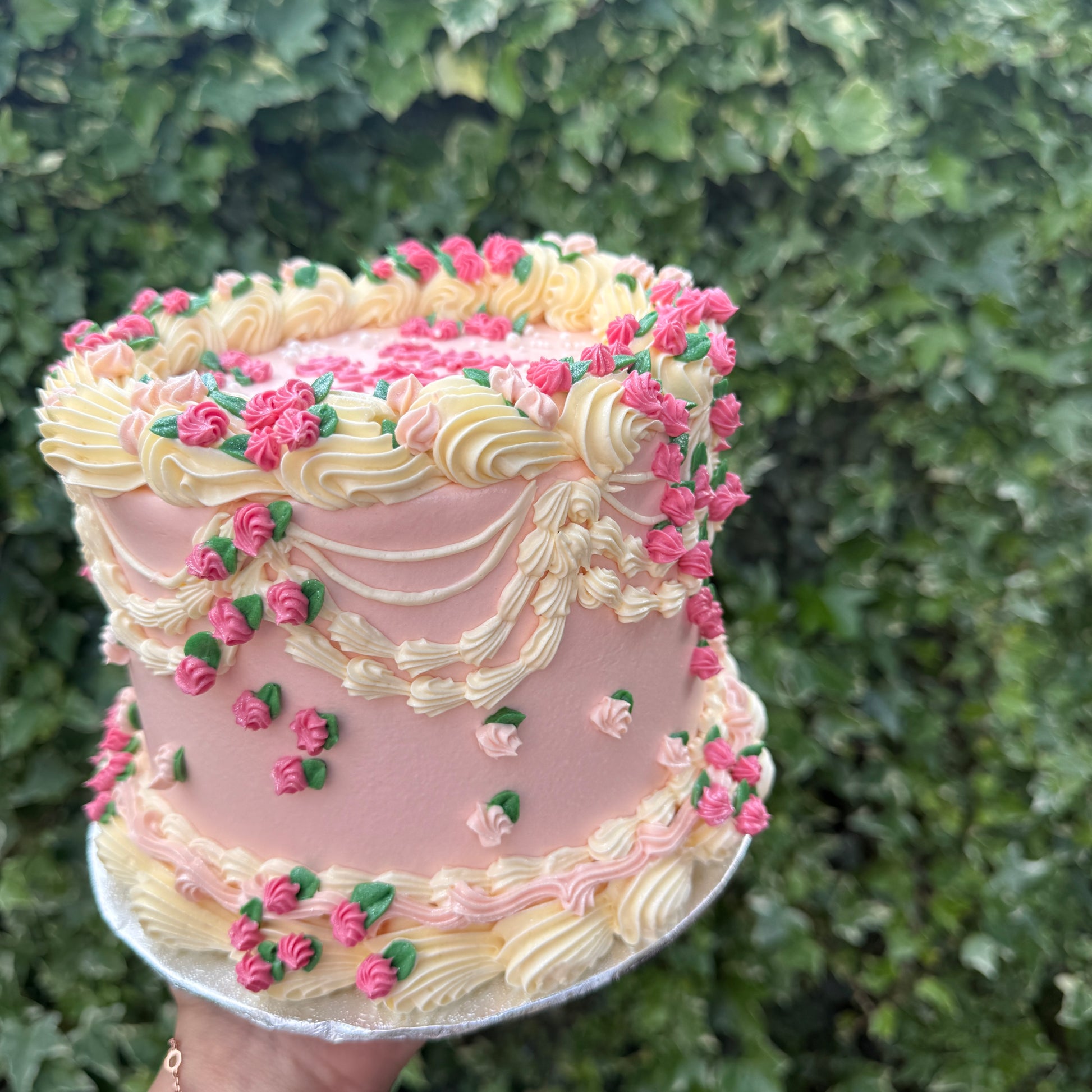 Pink vintage buttercream cake with cream rosette swags and dainty rosebuds — custom cakes East London, Romford and Ilford.