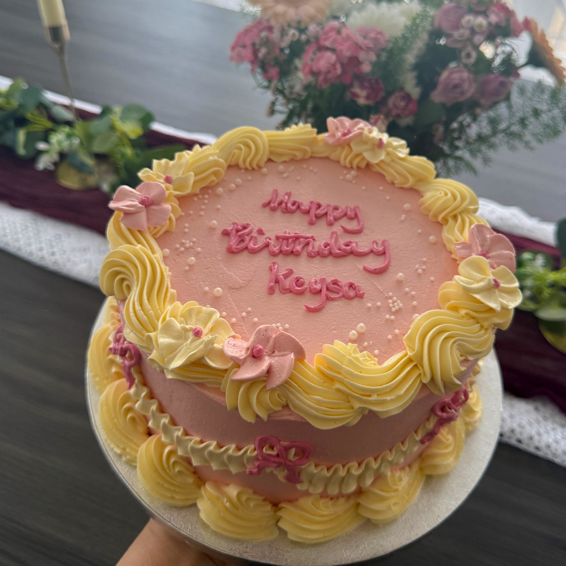 Pink and yellow vintage buttercream cake with piped flowers and bows, custom cakes East London, Romford and Ilford.
