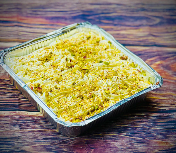 Pistachio Milk Cake Tray topped with crushed pistachios in an aluminium tray, delivery in Romford and Ilford, East London.