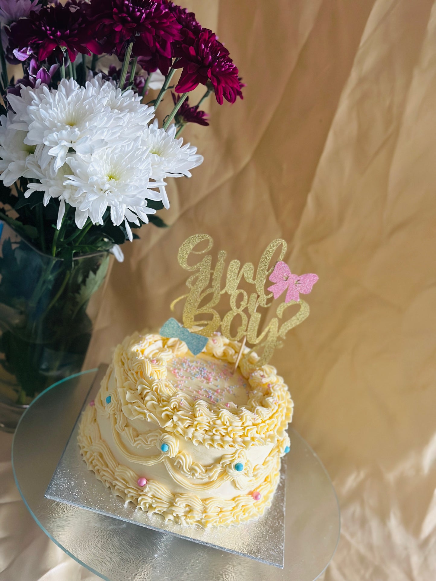 Girl or Boy? buttercream gender reveal cake with gold topper