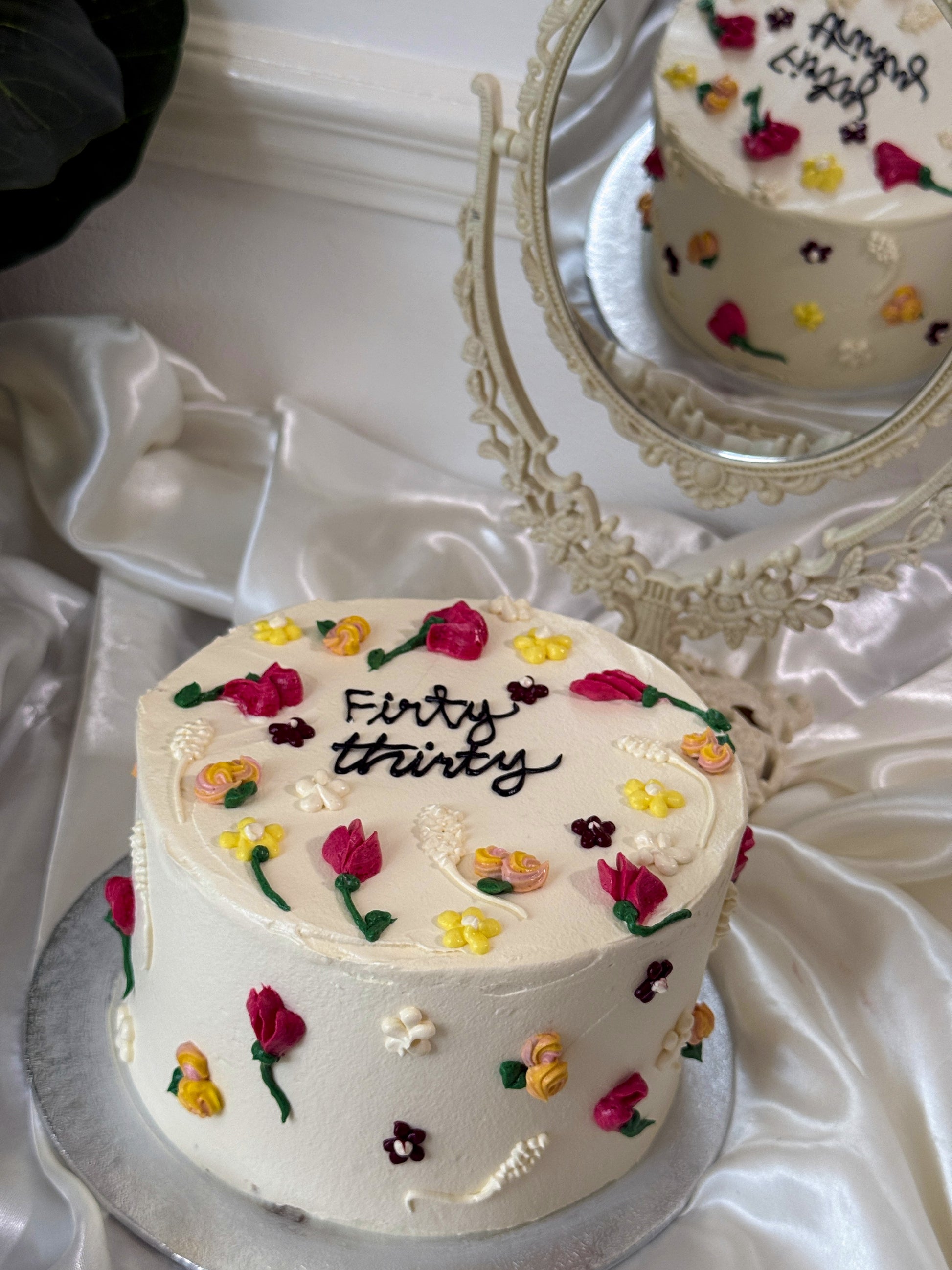 Side view of white buttercream wildflower celebration cake, custom cakes East London, Romford and Ilford.