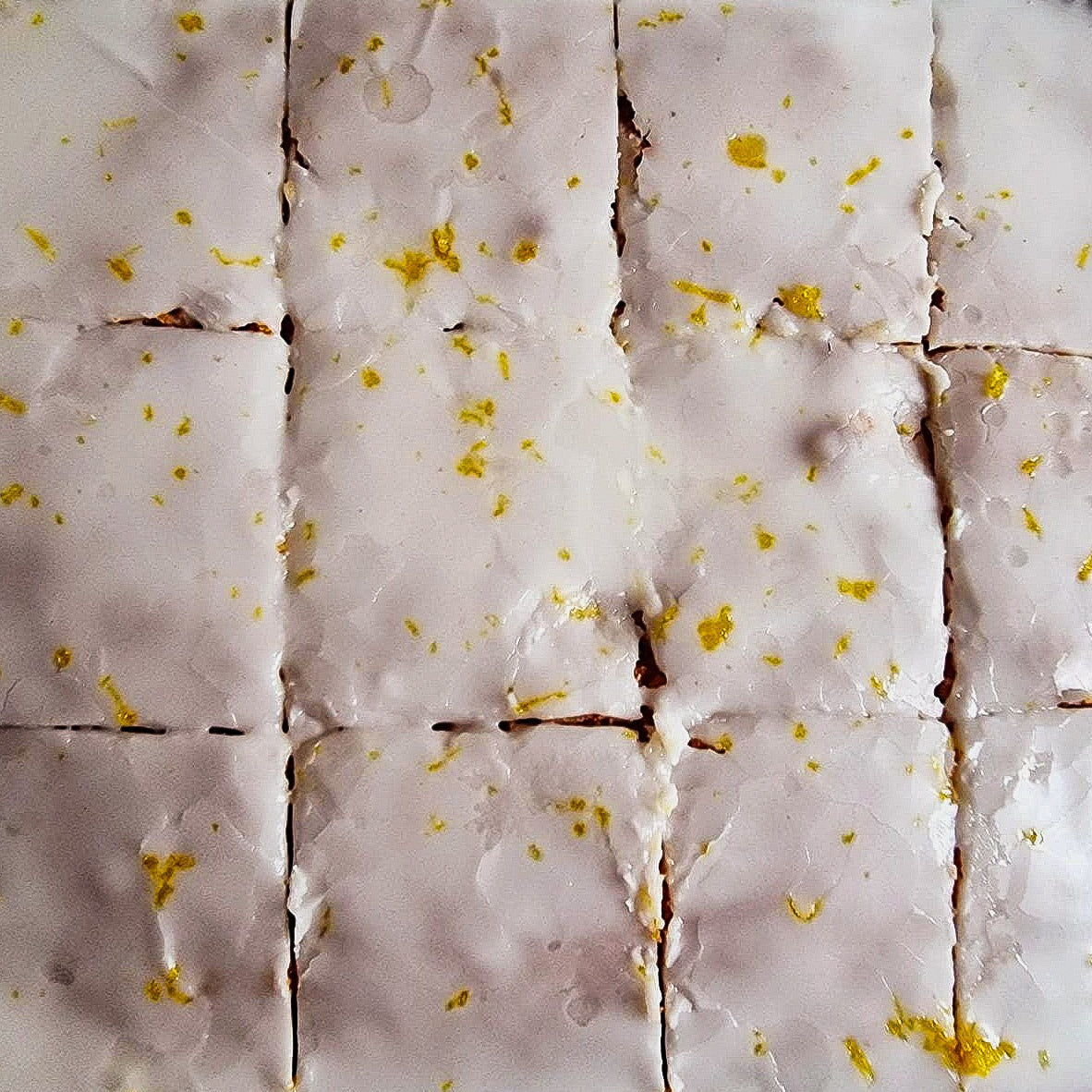 Close view of classic lemon tray bake cut into iced squares, delivered to Dagenham and Barking.